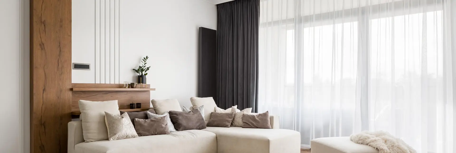 Lichtdoorlatende witte gordijnen gecombineerd met donkere overgordijnen in een woonkamer